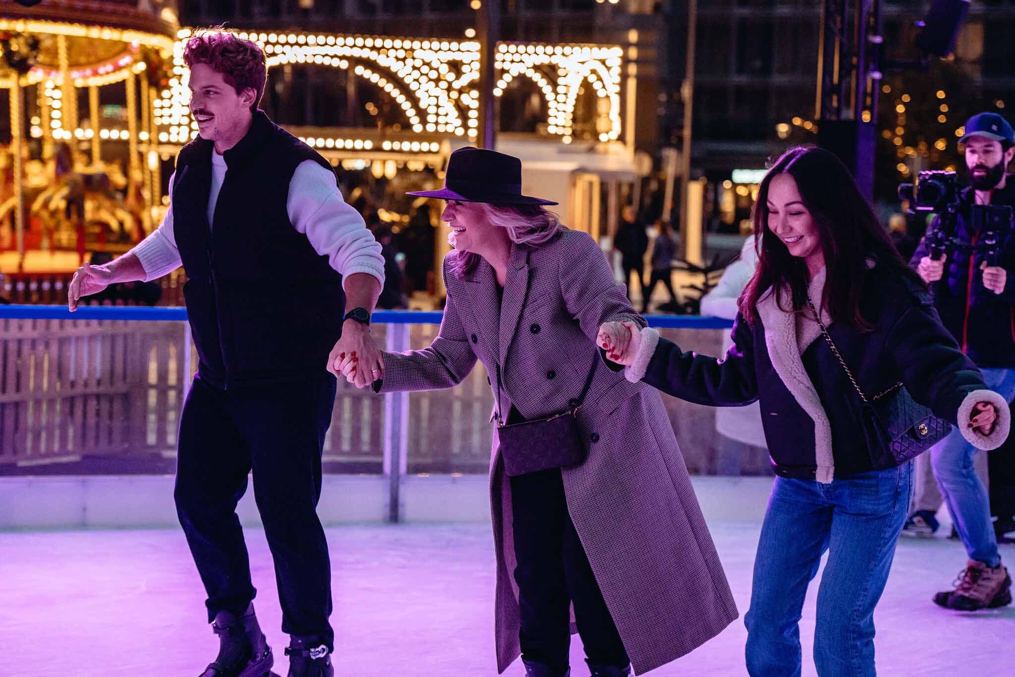 A trio of friend holding hands whilst skating