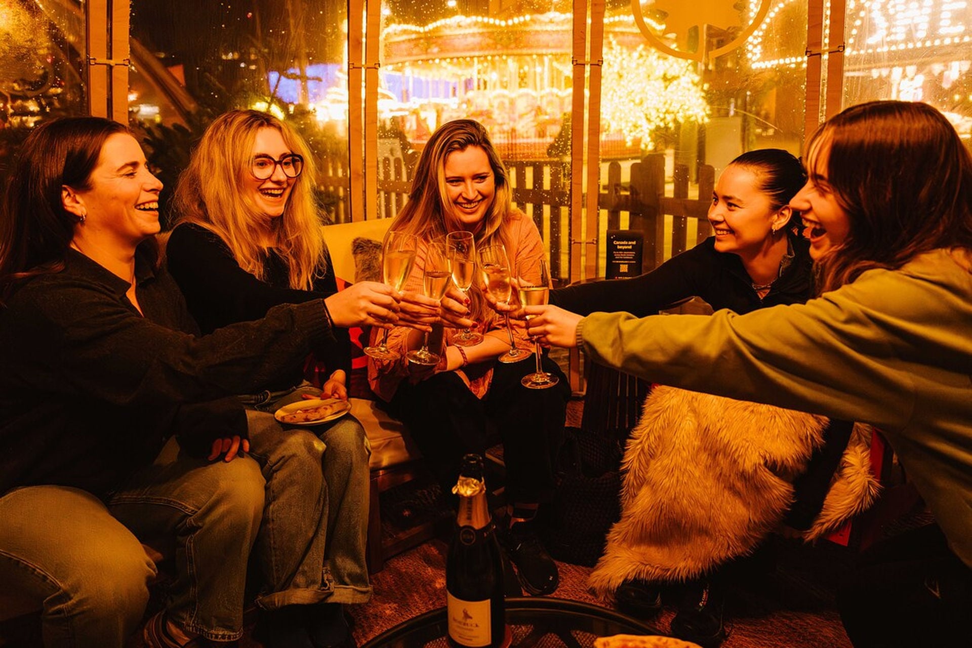 Friends cheers-ing drinks in igloo