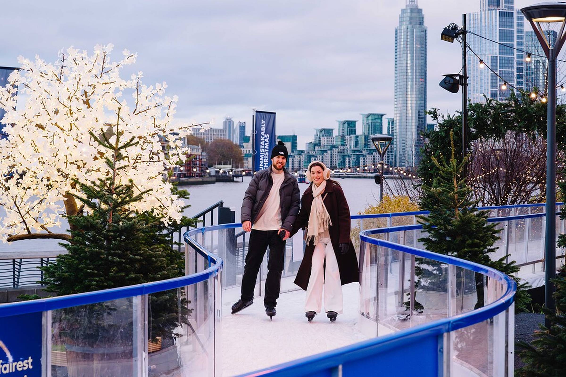 Couple on skate trail with London skyline in the background